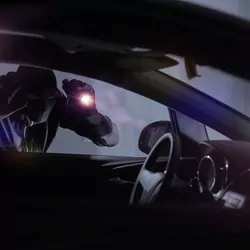 Masked man peering into car at night