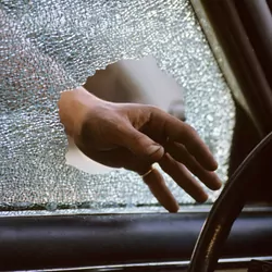 hand entering broken car window